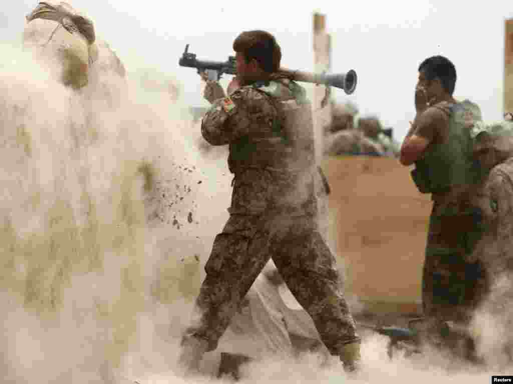 An Afghan Army soldier fires a rocket-propelled grenade at suspected Taliban militants at Combat Outpost Nolen in the Arghandab Valley north of Kandahar on July 22. Photo by Bob Strong for Reuters