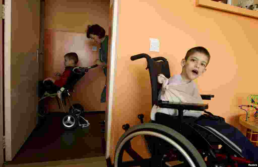 A Belarusian nurse pushes a child on a wheelchair.