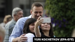 Two women take a photo with Russian opposition politician Aleksei Navalny after he voted in the Moscow City Duma elections.