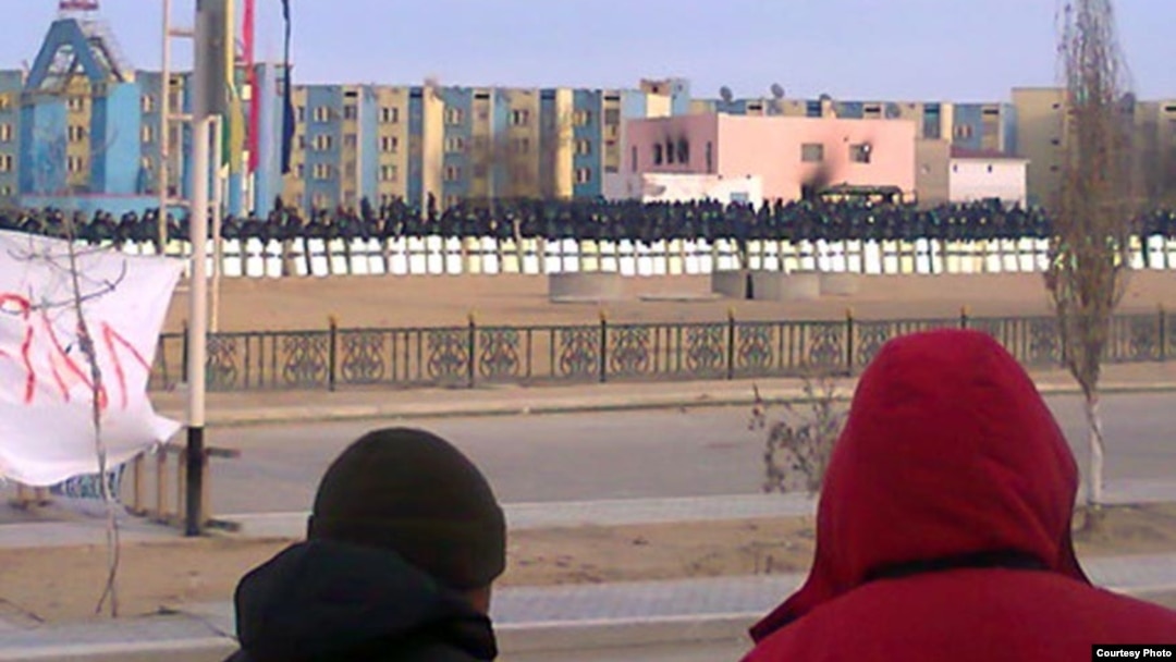 Locals watch in January as security forces occupy the square in Zhanaozen where clashes killed at least 16 people on December 16.