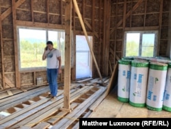 Mikhail Utrobin in the house he’s building for his family, with a view of the Khekhtsir Mountains. “People in our country don’t want to work,” he says.