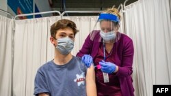 16-річний американець Томас Ґрегорі отримує дозу вакцини від COVID-19