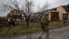 Ukrainian servicemen walk at a street in the frontline town of Lyman