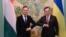 Ukrainian Foreign Minister Dmytro Kuleba (right) greets his Hungarian counterpart, Peter Szijjarto, in Kyiv on June 25. 