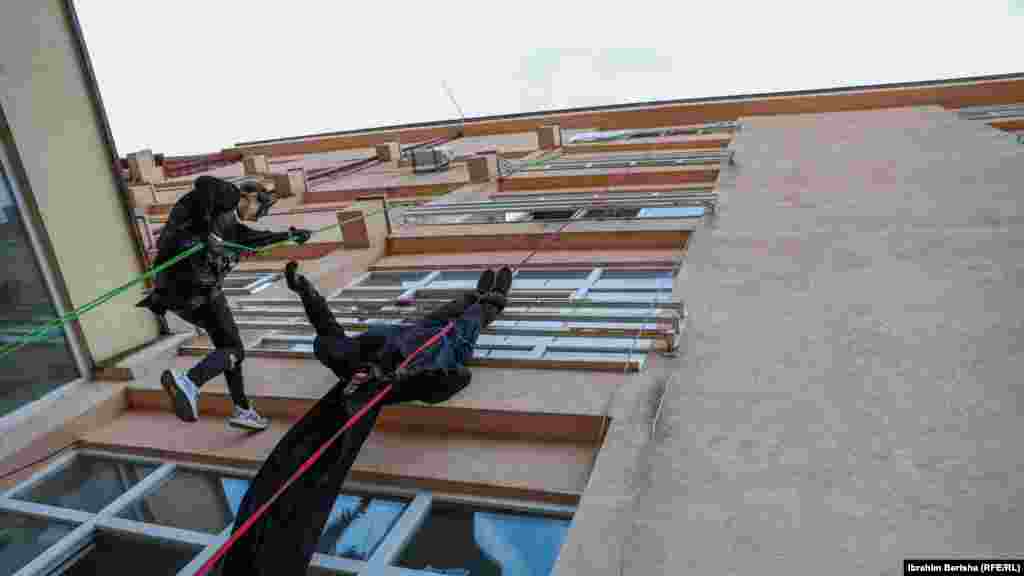 Dva penjača obučena kao Betmen spuštaju se konopcima na Pedijatrijskoj klinici u Prištini.