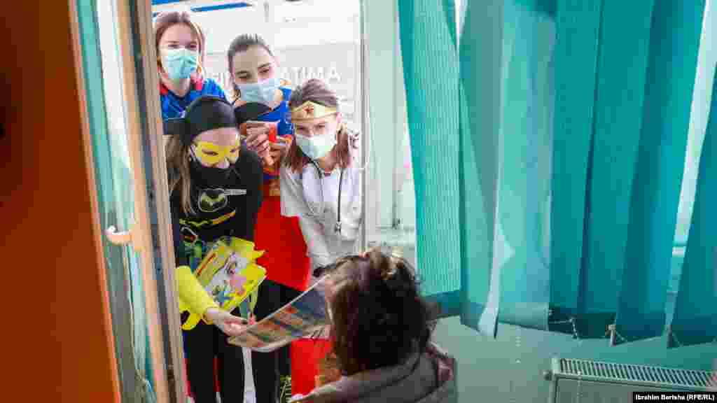 Neki aktivisti obučeni u različitu odjeću dijele poklone djeci u Pedijatrijskoj klinici u Prištini.