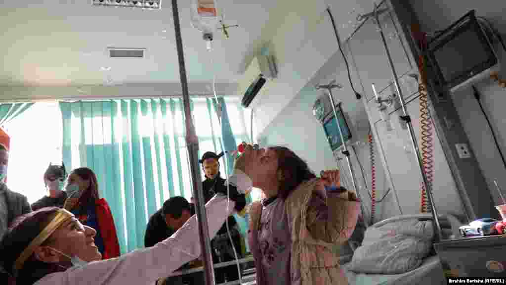 Žena obučena kao doktorica igra se sa djetetom u bolnici.