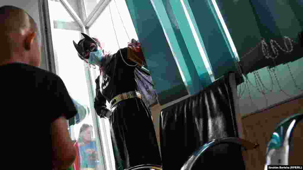 Žena obučena kao Betmen razgovara sa djetetom na Pedijatrijskoj klinici u Prištini.