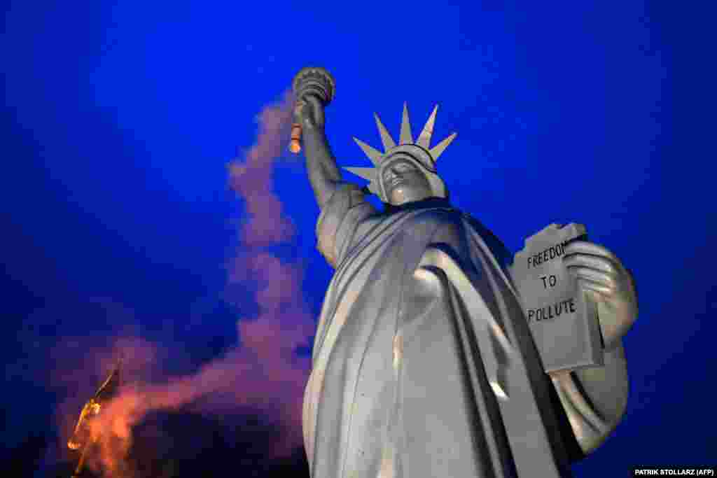 A replica of the Statue of Liberty emits smoke from its torch in a work created by Danish artist Jens Galschiot and displayed at the Rheinaue park during the COP23 United Nations Climate Change Conference in Bonn, Germany. (AFP/Patrik Stollarz)