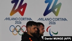 Милан шаарында Олимпиада жана Паралимпиада оюндарынын логотибинин жанынан өтүп бара жаткандар