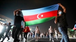 People carry the Azerbaijni national flag as they rally in support of the country's army in Baku on July 14.