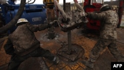 Floor hands connect 10-meter sections of steel pipe at a natural gas well site in the Barnett Shale field of Fort Worth, Texas. (file photo)