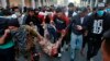 A soldier, badly wounded during clashes with anti-government protesters, is carried by demonstrators to a hospital during the ongoing protests in Baghdad on November 26.