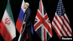 Secretarul de Stat american John Kerry, părăsind scena după "fotografia de familie" din finalul negocierilor de la Vena, 14 iulie 2015