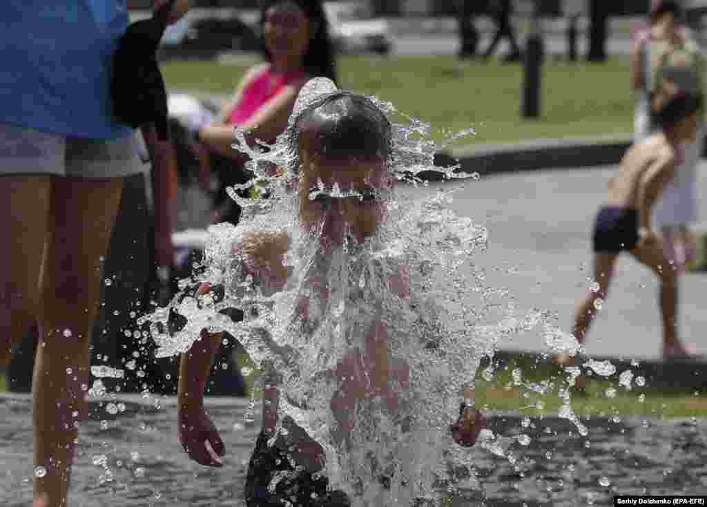 An Ukrainian boy plays in a fountain on Kyiv&#39;s Independence Square on July 1.&nbsp;