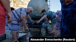 У Донецьку перебої з водою почалися після російської окупацією у 2014 році, і з роками лише поглибились. На фото: люди у черзі за водою, окупований Донецьк, серпень 2025 року