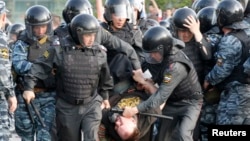 Полиция задерживает одного из участников акции протеста на Болотной площади в Москве. 6 мая 2012 года.