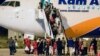 Refugjatët afganë zbresin nga një aeroplan pas mbërritjes në Aeroportin Ndërkombëtar të Shkupit, në Shkup më 30 gusht 2021. 