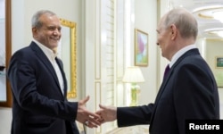 Russiýanyň prezidenti Wladimir Putin (sagda) Eýranyň Prezidenti Masud Pezeşkiýan bilen Awazada duşuşýar.