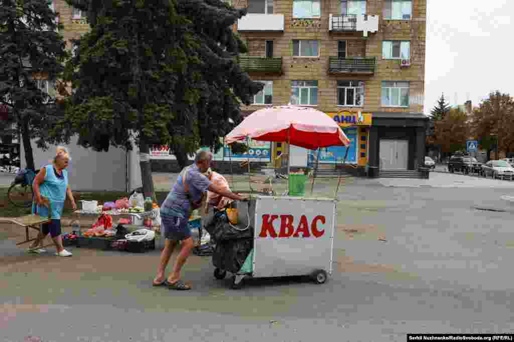 Мужчина, продающий квас, откатывает тележку со своей небольшой торговой точкой перед комендантским часом. Он действует в Покровске с 15 часов и до утра