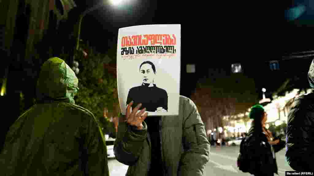 თბილისი - აქციის მონაწილეს ხელში უჭირავს პლაკატი დაპატიმრებული ჟურნალისტის, მზია ამაღლობელის გამოსახულებით.ფოტო: ილია რატიანი