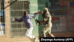 Demonstrant i policajac na ulicama Hararea, Zimbabve