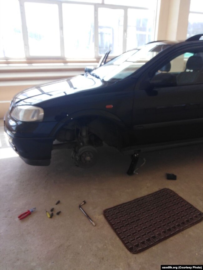 Тожикистон фуқароси машинаси ғилдирагини ечмоқда