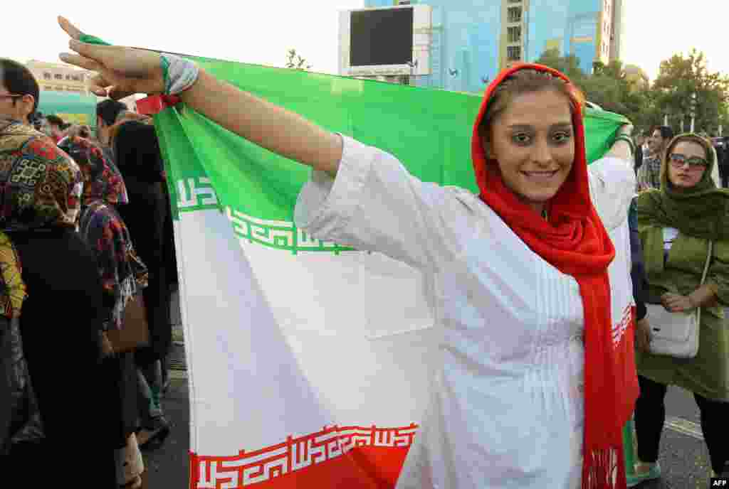An Iranian woman celebrates her national team&#39;s 1-0 football victory against South Korea. The win means that Iran will go on to the World Cup in Brazil in 2014. (AFP/Atta Kenare)
