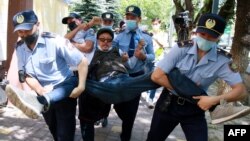 Kazakh police detain a demonstrator during opposition protests in June 2020 in Almaty.