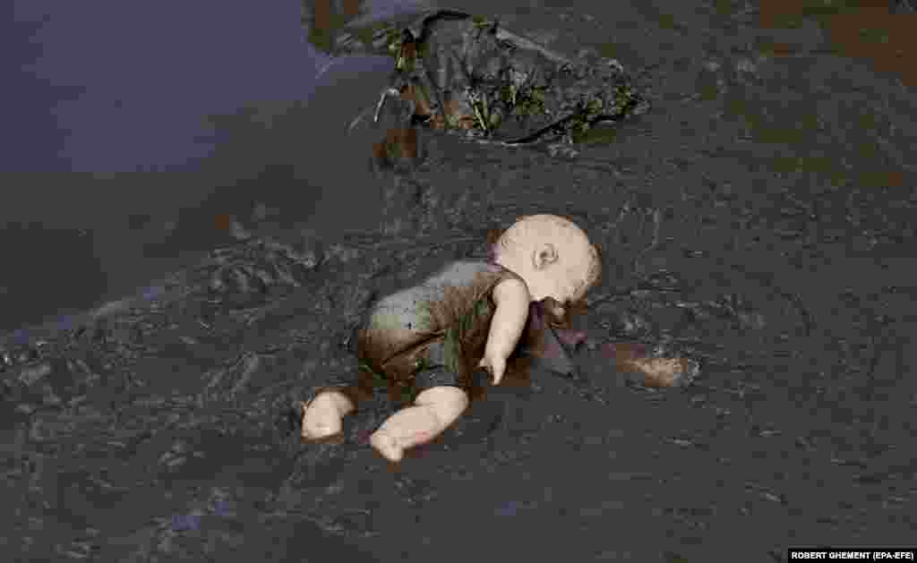 A plastic doll lays face down in the mud in the flood-hit village of Pechea, near the Romanian city of Galati.