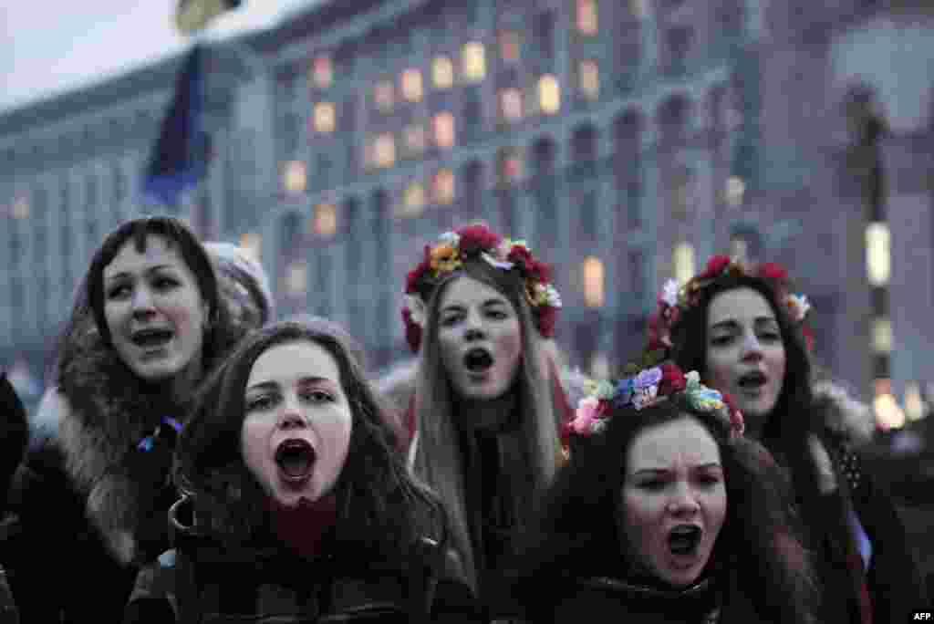 Young girls chant the song 'Glory to Ukraine ' on Independence Square in central Kyiv on February 26. (AFP/Louisa Goulimaki) 