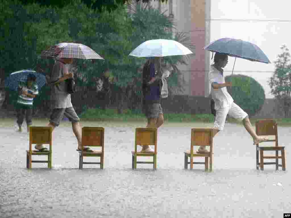 Chinese students make their way across a flooded school compound on June 18 in China's Hubei Province. More than 1 million people were evacuated in China following downpours that raised water levels in rivers to critical highs while also triggering floods and landslides.Photo by CHINA OUT/AFP