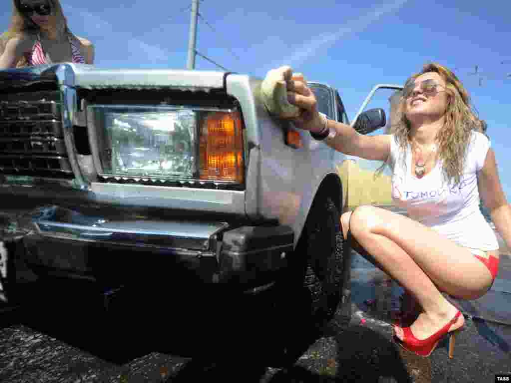 Members of a social network group, who claim to be fans of Russian Prime Minister Vladimir Putin, stage a free outdoor car wash in Moscow in support of Russian carmakers on July 21.Photo by Alexandra Mudrats for ITAR-TASS