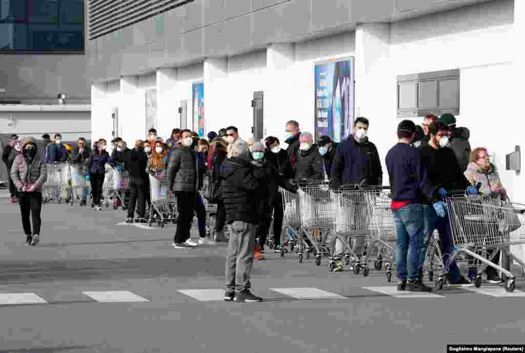 Люди стоят в очереди возле супермаркета в городе Казальпустерленго, в котором итальянские власти объявили карантин