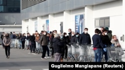Люди стоять в черзі біля супермаркету в місті Казальпустерленго, в якому італійська влада оголосила карантин