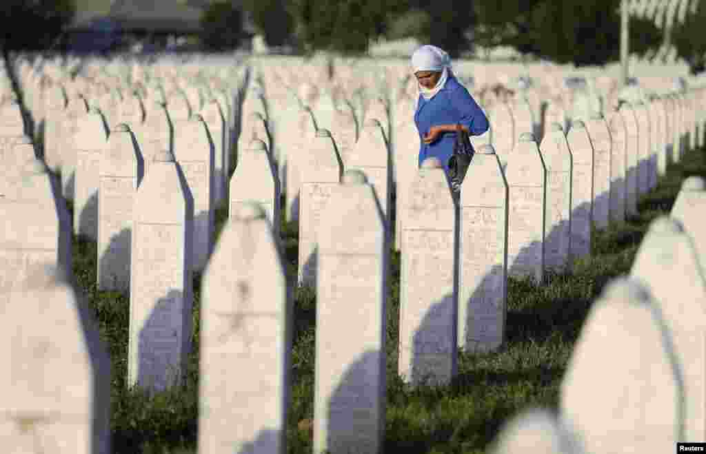 A woman walks among graves in the Potocari Memorial Center Potocari, near Srebrenica, on the anniversary of the notorious Balkan war massacre there on July 11, 1995. (Reuters/Dado Ruvic)