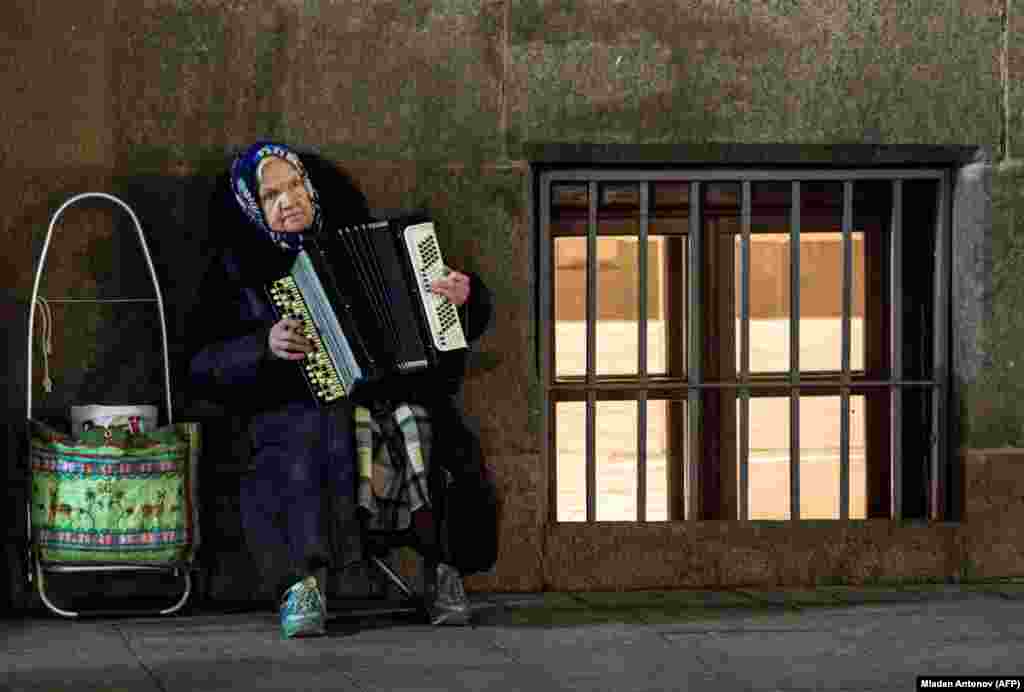 An elderly woman plays an accordion on the street in Moscow. (AFP/Mladen Antonov)