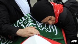 Cigdem Topcuoglu, the wife of slain activist Cetin Topcuoglu mourns over his coffin at an Istanbul mosque on June 3.