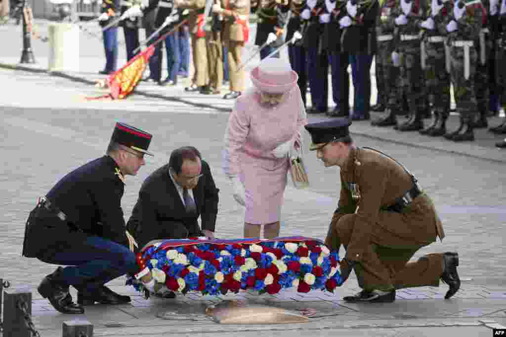 Екінші Елизавета Париждегі Триумф аркасында Франция президенті Франсуа Олландпен бірге белгісіз солдат бейітіне гүл шоқтарын қойып тұр. 5 маусым 2014 жыл.&nbsp;