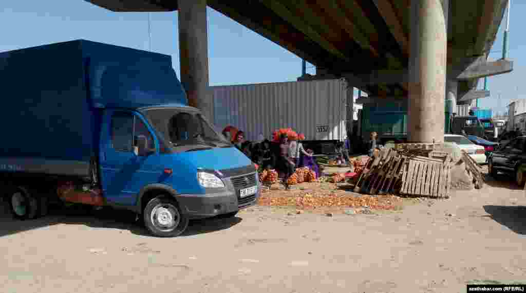 Sogany ýük ulagyna ýükleýän söwdagärler.