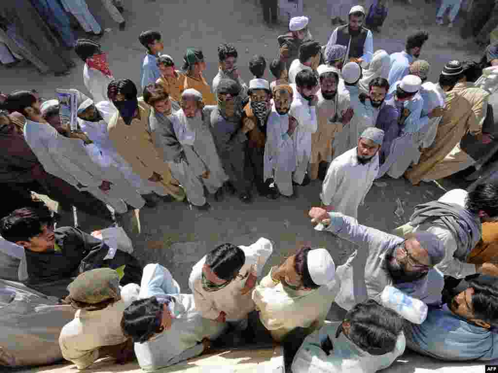 Pakistan -- Internally displaced Pakistani civilians, fleeing from military operations against Taliban militants in South Waziristan, queue for relief food outside a distribution point in Paharpur village, 23Oct2009 - Del330559 PAKISTAN, Paharpur : Internally displaced Pakistani civilians, fleeing from military operations against Taliban militants in South Waziristan, queue for relief food outside a distribution point in Paharpur village some 40 km from Dera Ismail Khan on October 23, 2009. Pakistani troops and Taliban militants have been locked in intense clashes on the sixth day of a major military assault in the tribal belt which has killed more than 150 people. Around 30,000 troops are taking part in the offensive against an estimated 10-12,000 militants in the semi-autonomous and lawless tribal belt. Relief workers say that more than 120,000 people have been displaced by the fighting.
