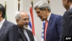 وزير الخارجية الأميركي جون كيري ونظيره الإيراني محمد جواد ظريف يتبادلان التهاني بعد التوصل الى إتفاق في جنيف.