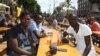 Three Congolese students have a beer in the fan zone in Kyiv. While some longtime residents stay away for fear of violence, visiting fans talk of a welcoming atmosphere.