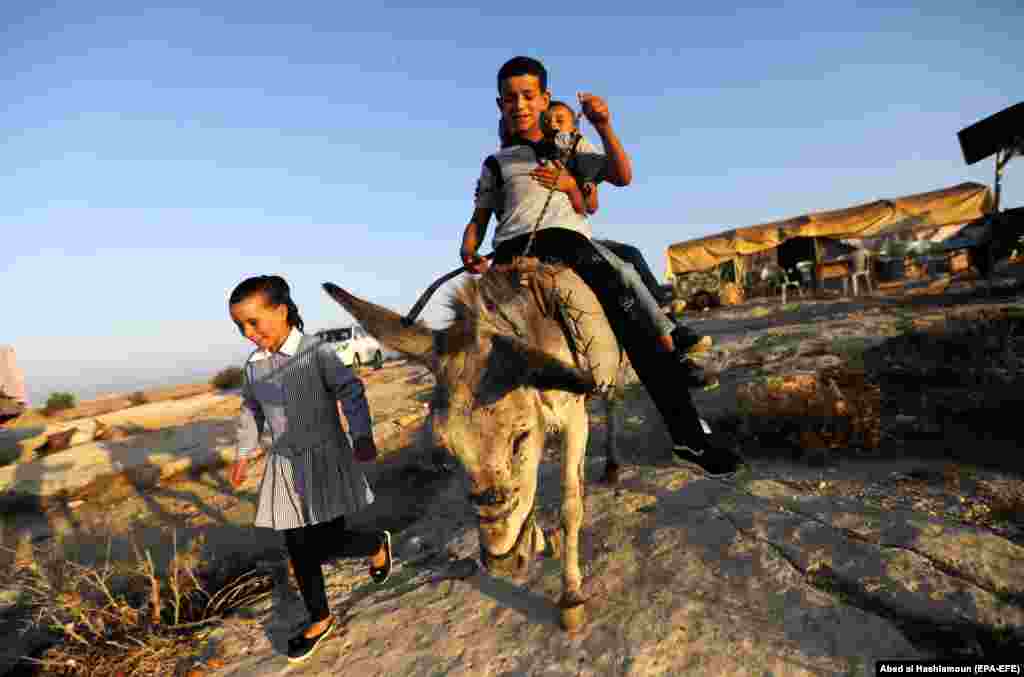 Palestinian children head to school on the first day of the new school year in the village of Sosia near Yatta, south of Hebron on the West Bank, on August 29. (EPA-EFE/Abed Al Hashlamoun)