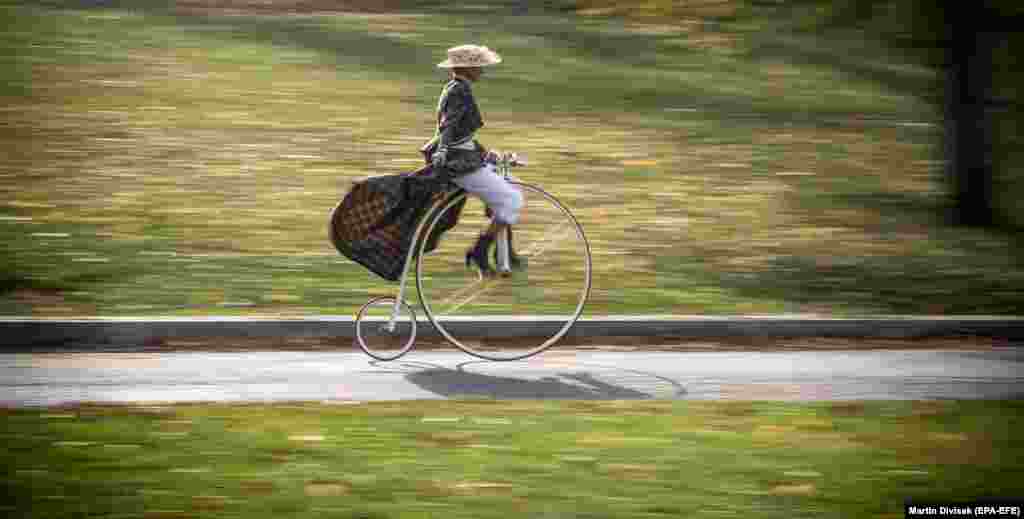 A woman wearing historical dress rides her high-wheel bicycle during the traditional Prague Mile race in Prague on November 4. (epa-EFE/Martin Divisek)