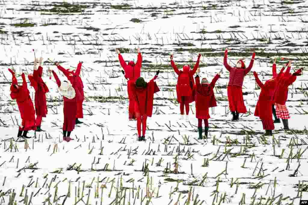 Женщины в красных одеждах танцуют, держа в руках красные тюльпаны, приветствуя наступление весны во время акции протеста против результатов президентских выборов в Беларуси возле села Малое Запрудье, примерно в 95 км к северо-западу от Минска, 1 марта