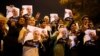 Iranian supporters of Foreign Minister Mohammad Javad Zarif flash the victory sign as he arrives at Tehran's Mehrabad Airport on November 24.