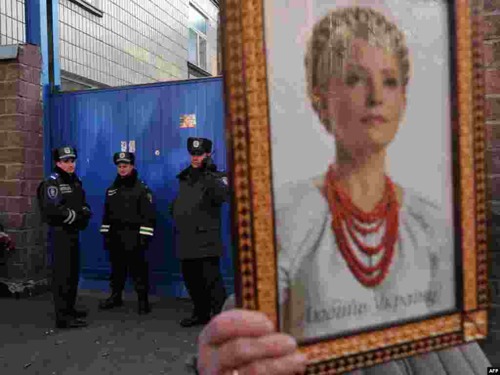 A supporter of Yulia Tymoshenko holds her portrait during a rally in front of the Kyiv prison where the former prime minister is being held. (AFP PHoto/ Sergei Supinsky)