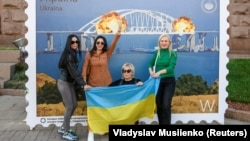 Малюнок у формі великої марки, на якій зображено Керченський міст у вогні. Центр Києва, 8 жовтні 2022 року 