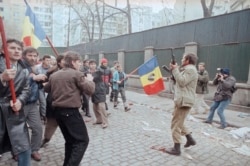 București, 27 decembrie, un soldat în civil trage în aer pentru a opri un protest.